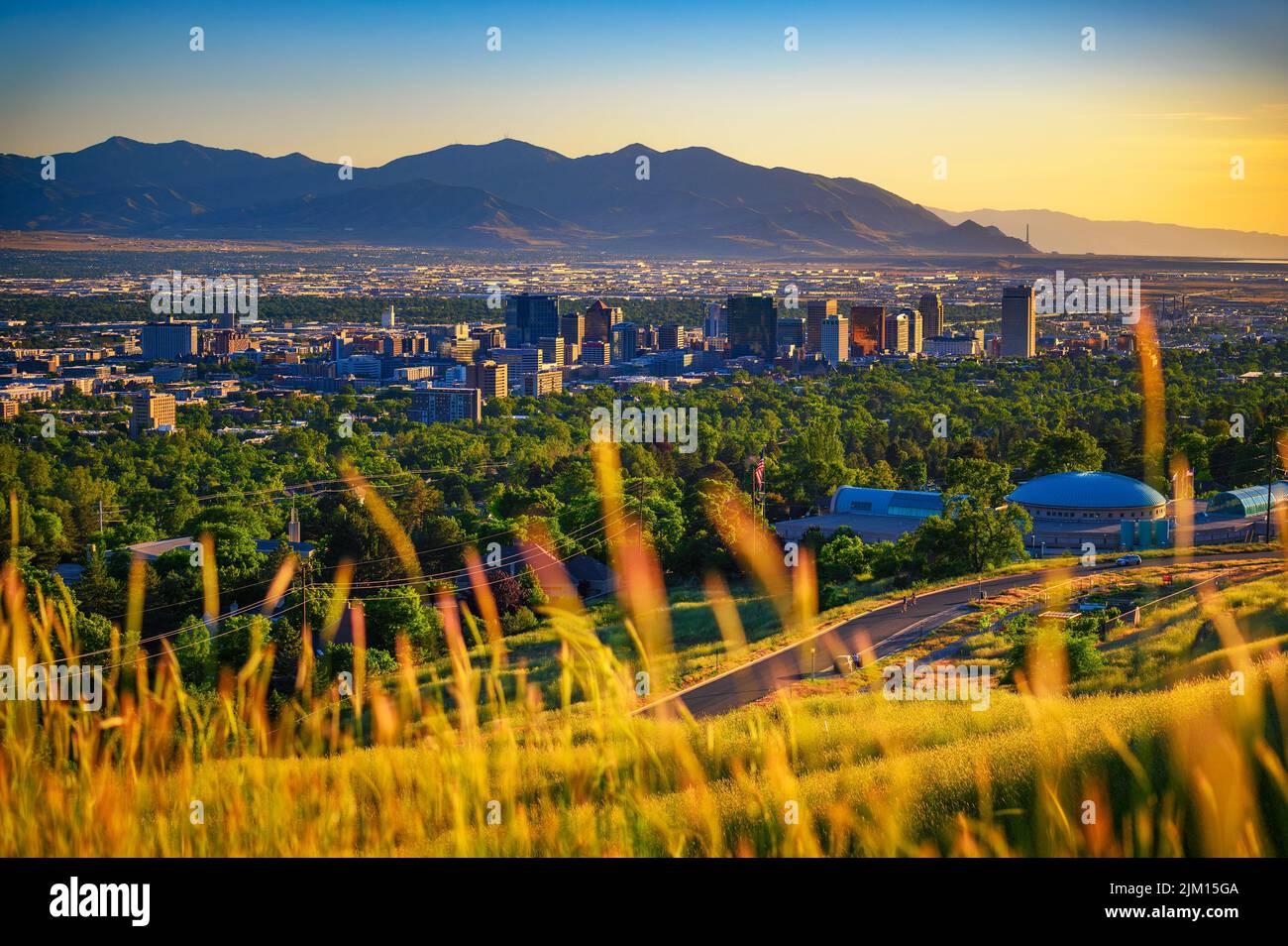 Skyline von Salt Lake City bei Sonnenuntergang mit Wasatch Mountains im Hintergrund, Utah Stockfoto