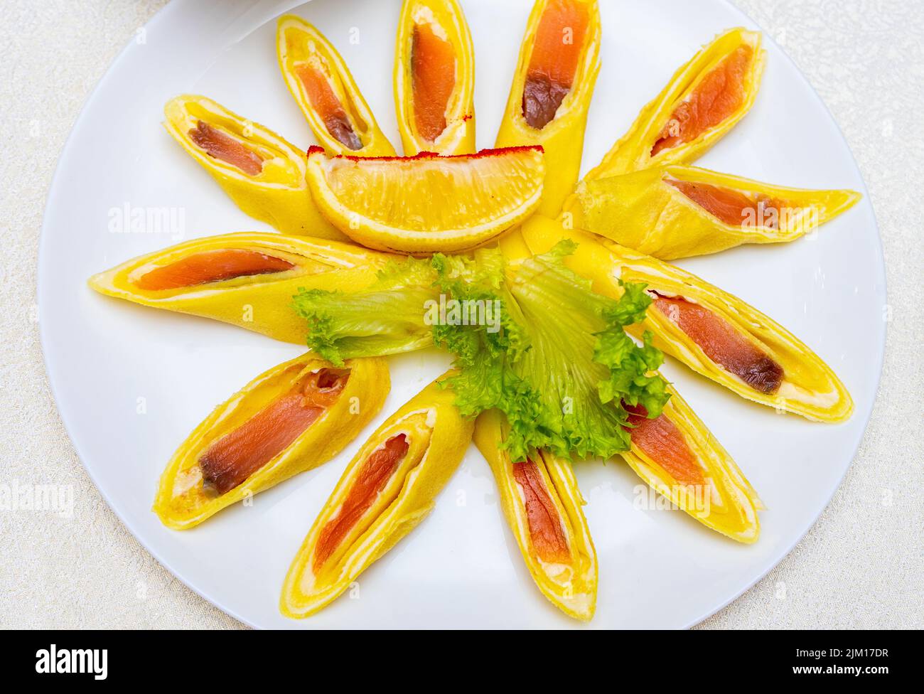 Pfannkuchen gefüllt mit rotem Fisch und in Stücke geschnitten. Teller mit Pfannkuchen aus nächster Nähe. Stockfoto