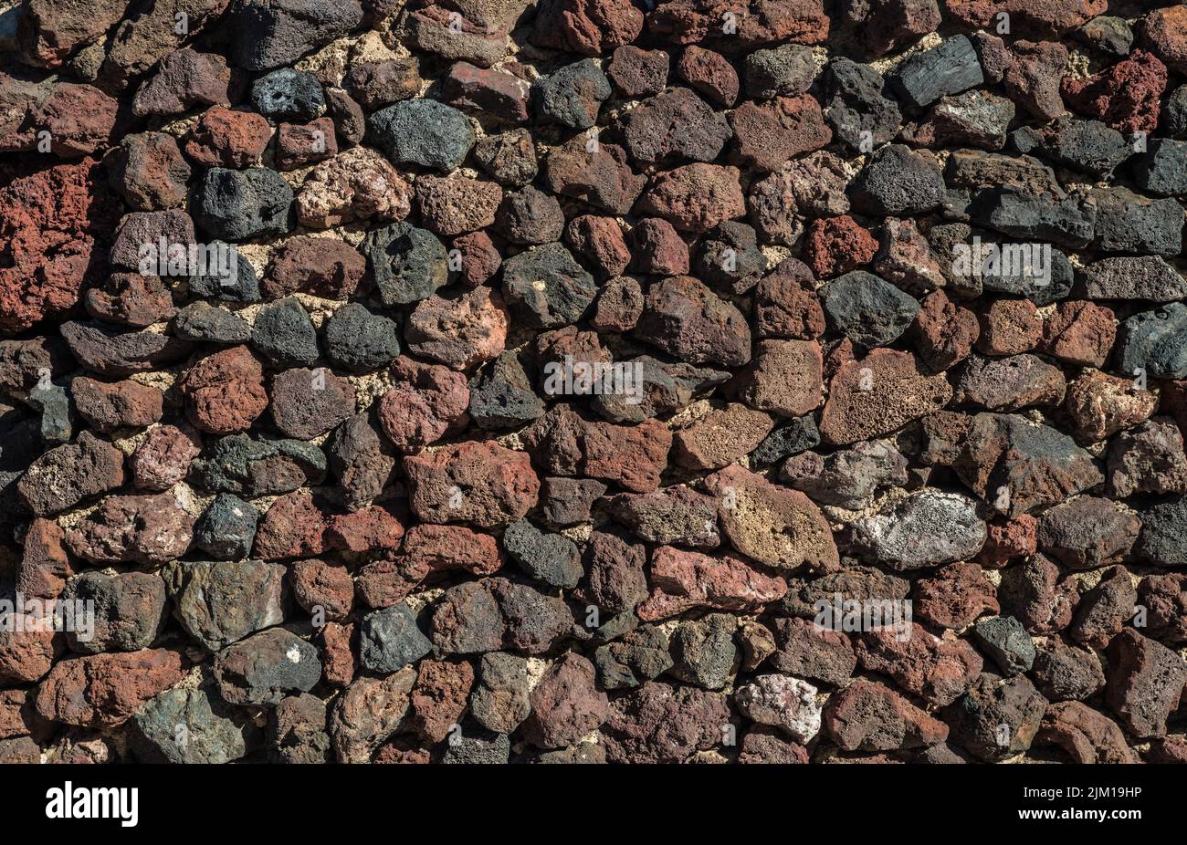 Wand aus Lavaresten oder unsterblichen Felsen gebaut. Nahaufnahme. Stockfoto