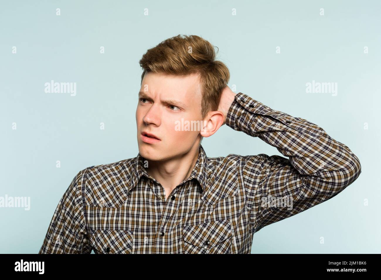 Ratlos verwirrt Mann kratzen Kopf aussehen eklig Stockfoto