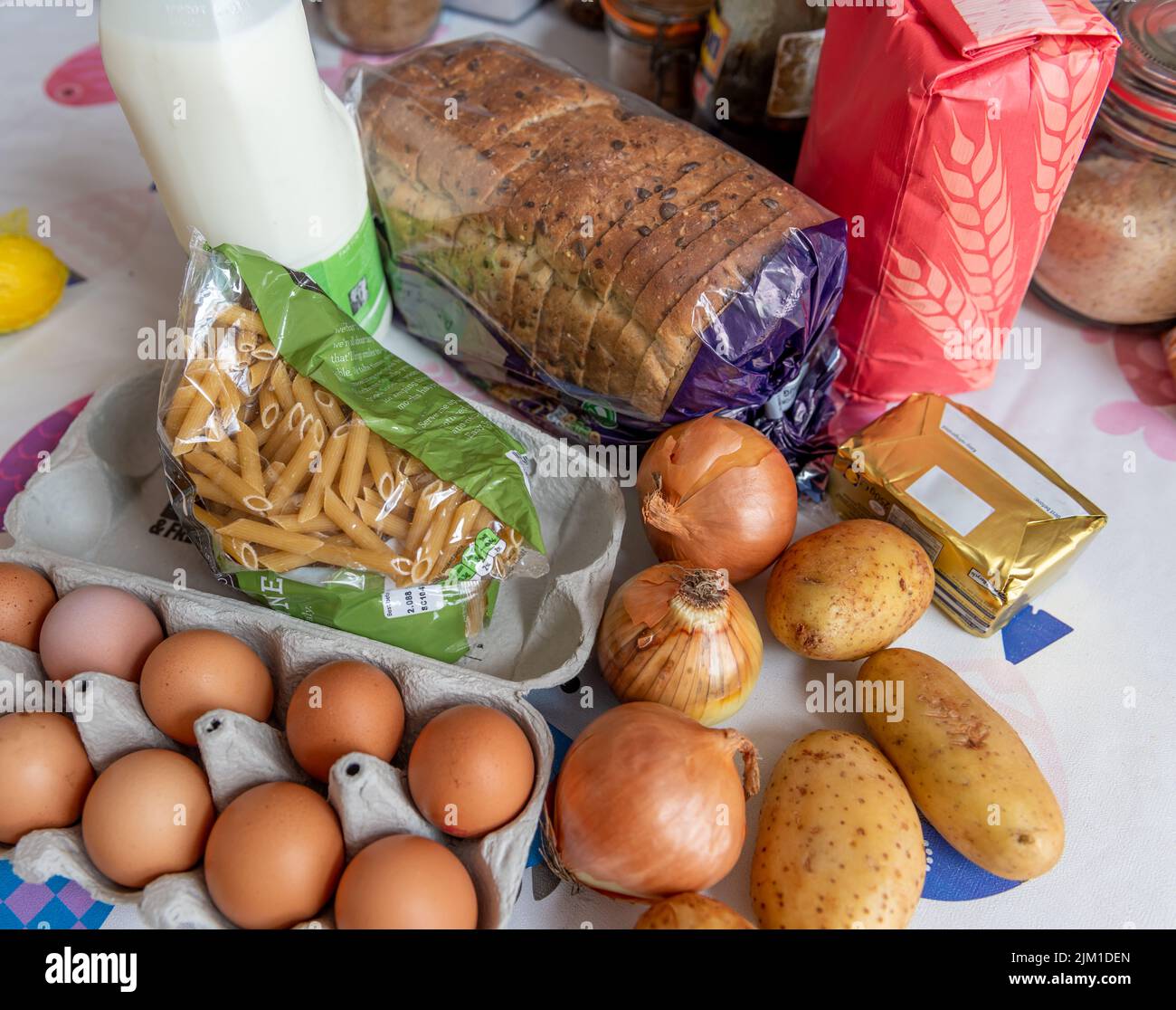Einfache oder alltägliche Lebensmittel auf einem Küchentisch. Lebensmittelkosten, Inflation, Lebenshaltungskosten Konzept. Stockfoto