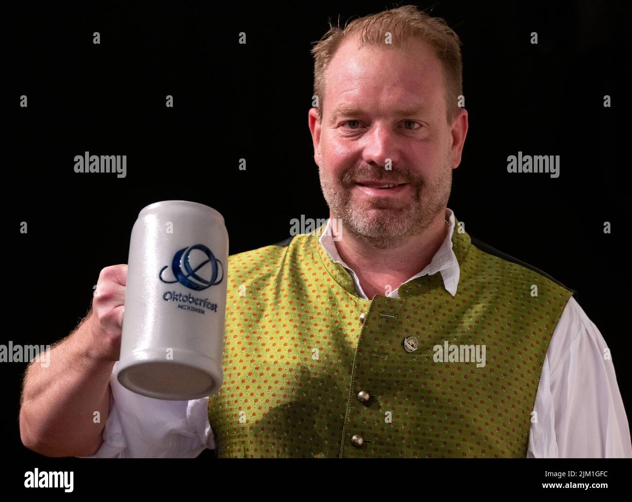 München, Deutschland. 04. August 2022. Andreas Maisberger, Geschäftsführer des Vereins Münchner Brauereien, nimmt an einer Pressekonferenz zum Oktoberfest 2022 Teil und präsentiert das neue Oktoberfest-Logo auf einem bierstein. Auf der Pressekonferenz wurden die Innovationen auf dem Oktoberfest 2022 vorgestellt. In diesem Jahr findet das Oktoberfest von 17.09.2022 bis 03.10.2022 statt. Quelle: Sven Hoppe/dpa/Alamy Live News Stockfoto