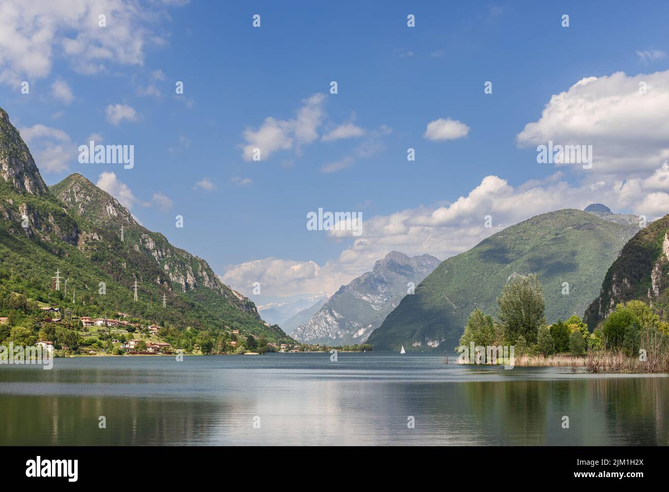 Panoramablick auf das ruhige Wasser des alpinen Sees Idro (Lago d'Idro), umgeben von Felsen und bewaldeten Bergen. Brescia, Lombardei, Italien Stockfoto