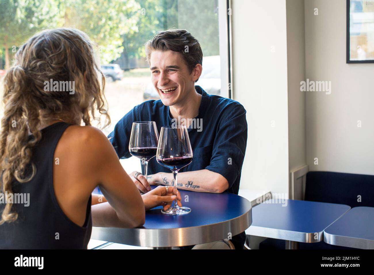 Das junge kaukasische Paar genießt Rotwein in der Weinbar Stockfoto