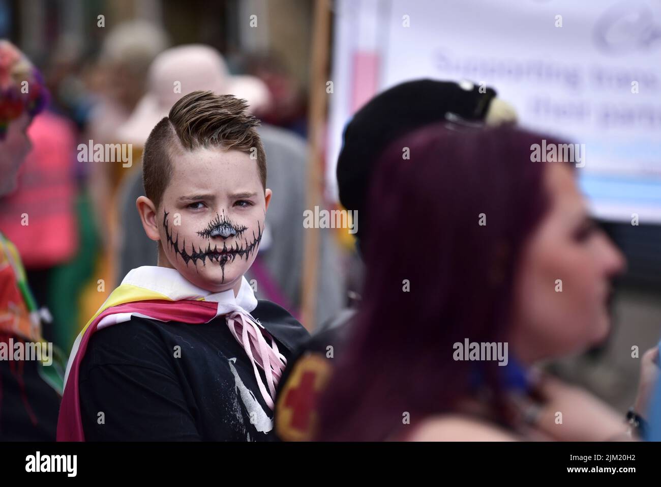 Ein kleiner Junge mit seinem Gesicht, der an der Cornwall Prides Pride Parade im Zentrum von Newquay in Großbritannien teilnahm. Stockfoto