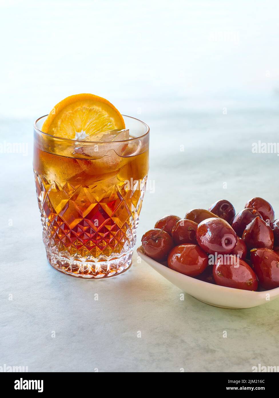 Ein Glas Wermut serviert mit einer klassischen Oliven-Tapa. Stockfoto