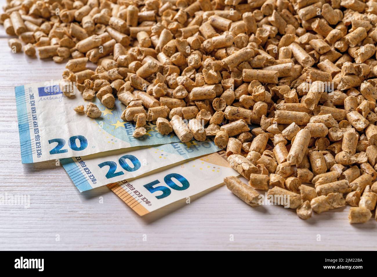 Holzpellets Haufen und Euro-Geld-Banknoten. Bio-Treibstoff kostet, kaufen und verkaufen Pellets. Bio-Biokraftstoff aus komprimiertem Sägemehl Preise. Ökologische Heizung. Stockfoto