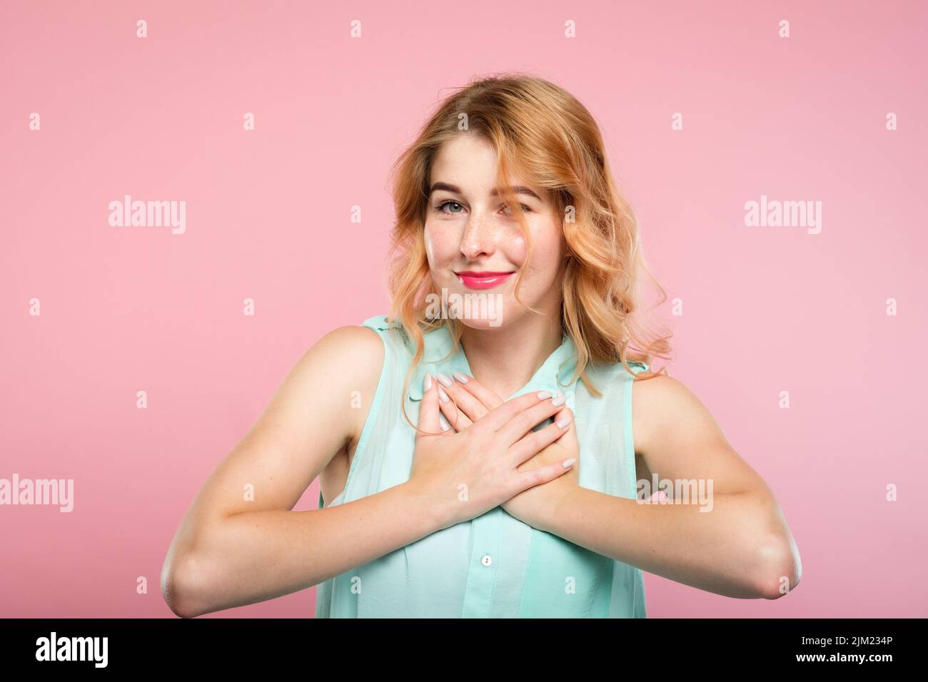 Geschmeicheltes Mädchen lächelnde Hand Herz angenehmes Gefühl Stockfoto