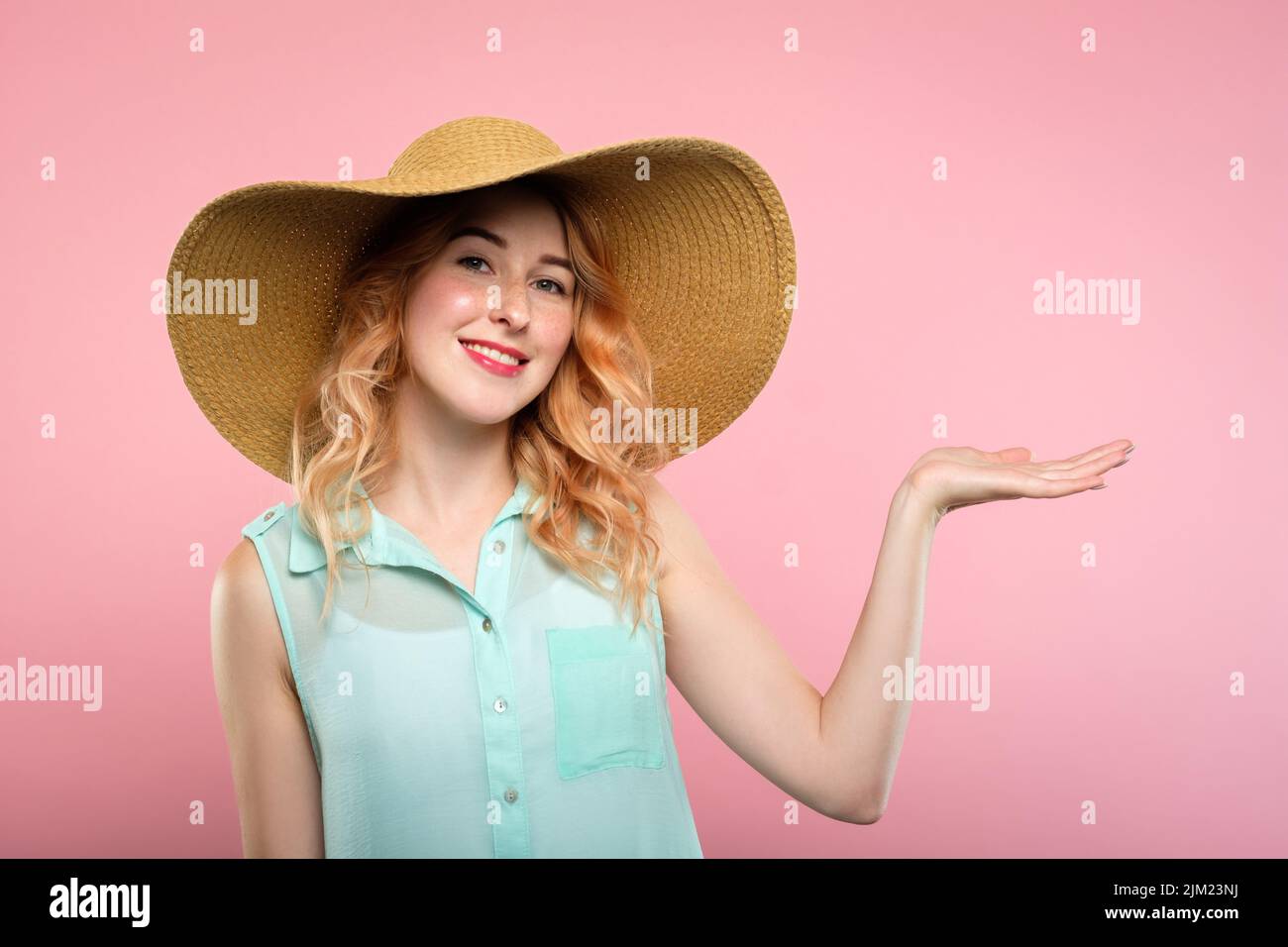 Lächelnde Frau Sonnenhut halten Hand Produktwerbung Stockfoto