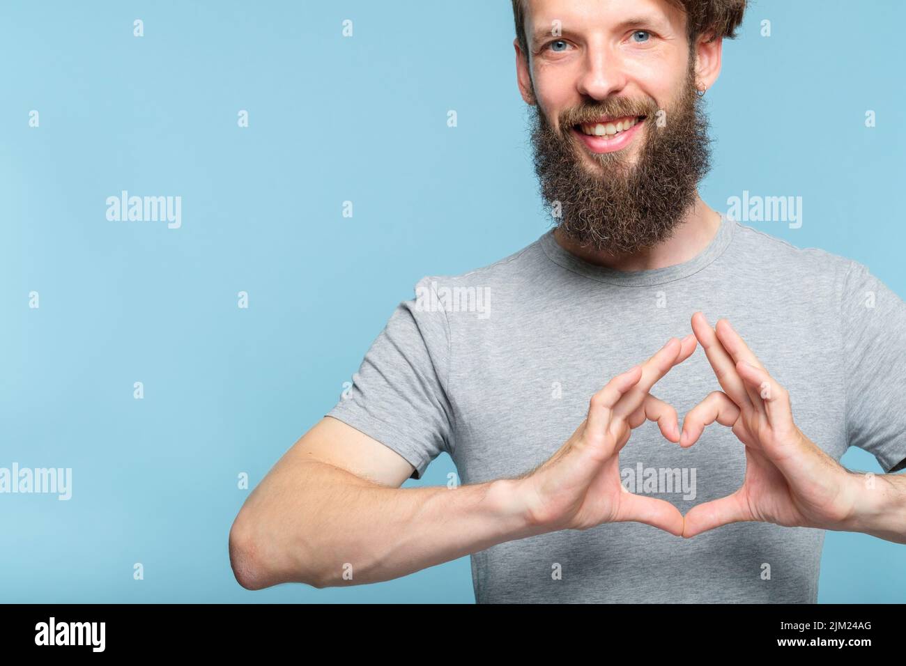 Liebe Emotion lächelnder Mann macht Herz Form Hände Stockfoto