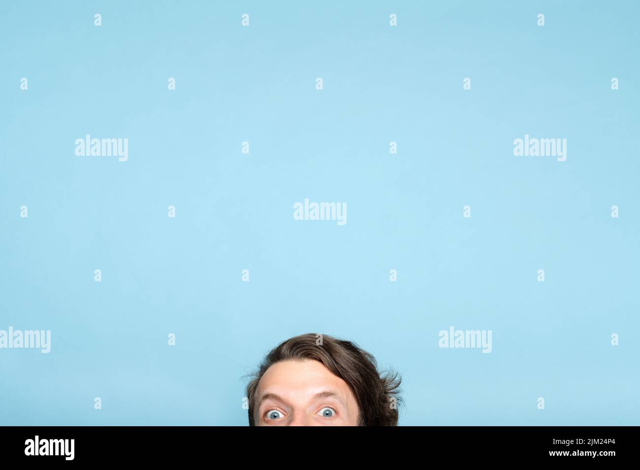 Aufgeschreckt exzentrischen Mann lächelnde Augen gucken aus unten Stockfoto