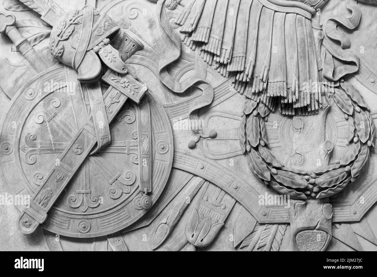 Schwarz-Weiß-Foto mit einer Vielzahl von antiken römischen Militärobjekten, die in einer Marmorwand geschnitzt wurden Stockfoto