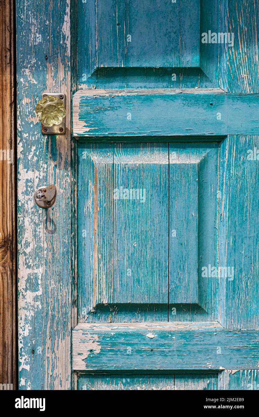 Fragment einer geschlossenen alten Holztür mit abblätternder Farbe Stockfoto