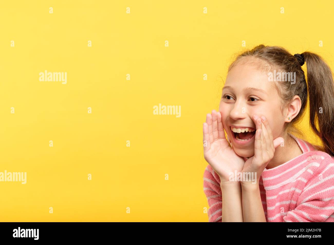 Lächelndes Mädchen reden so, als ob man ein Megaphon ankündigen würde Stockfoto