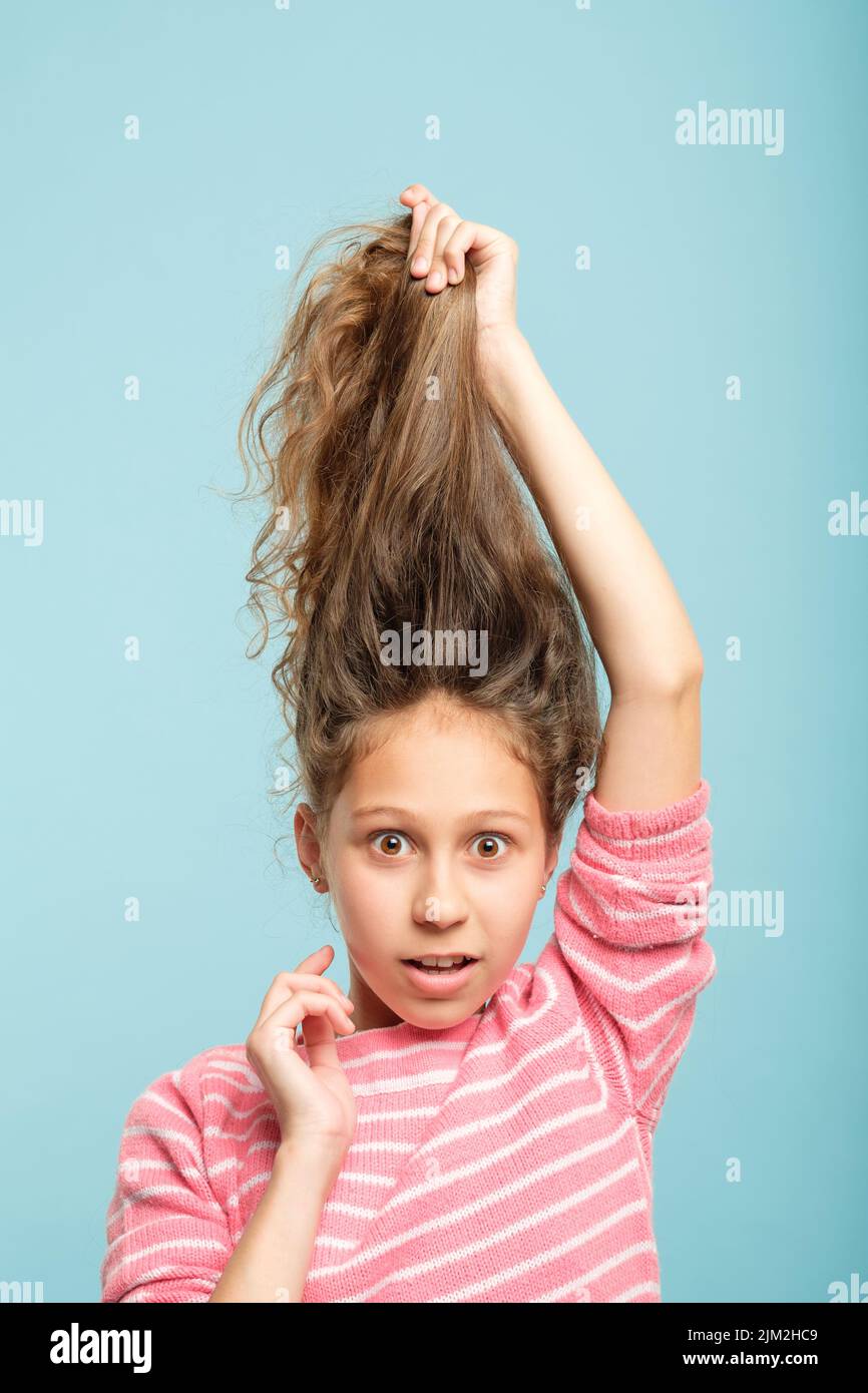 haircare Styling überrascht Mädchen halten unordentliche Haare Stockfoto