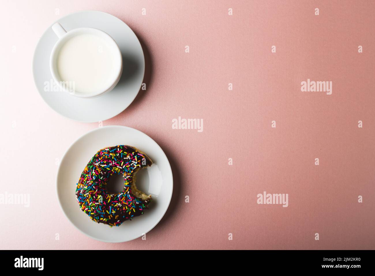 Overhead-Ansicht von Schokolade Donut in Teller für Tasse Milch und kopieren Raum auf farbigem Hintergrund Stockfoto