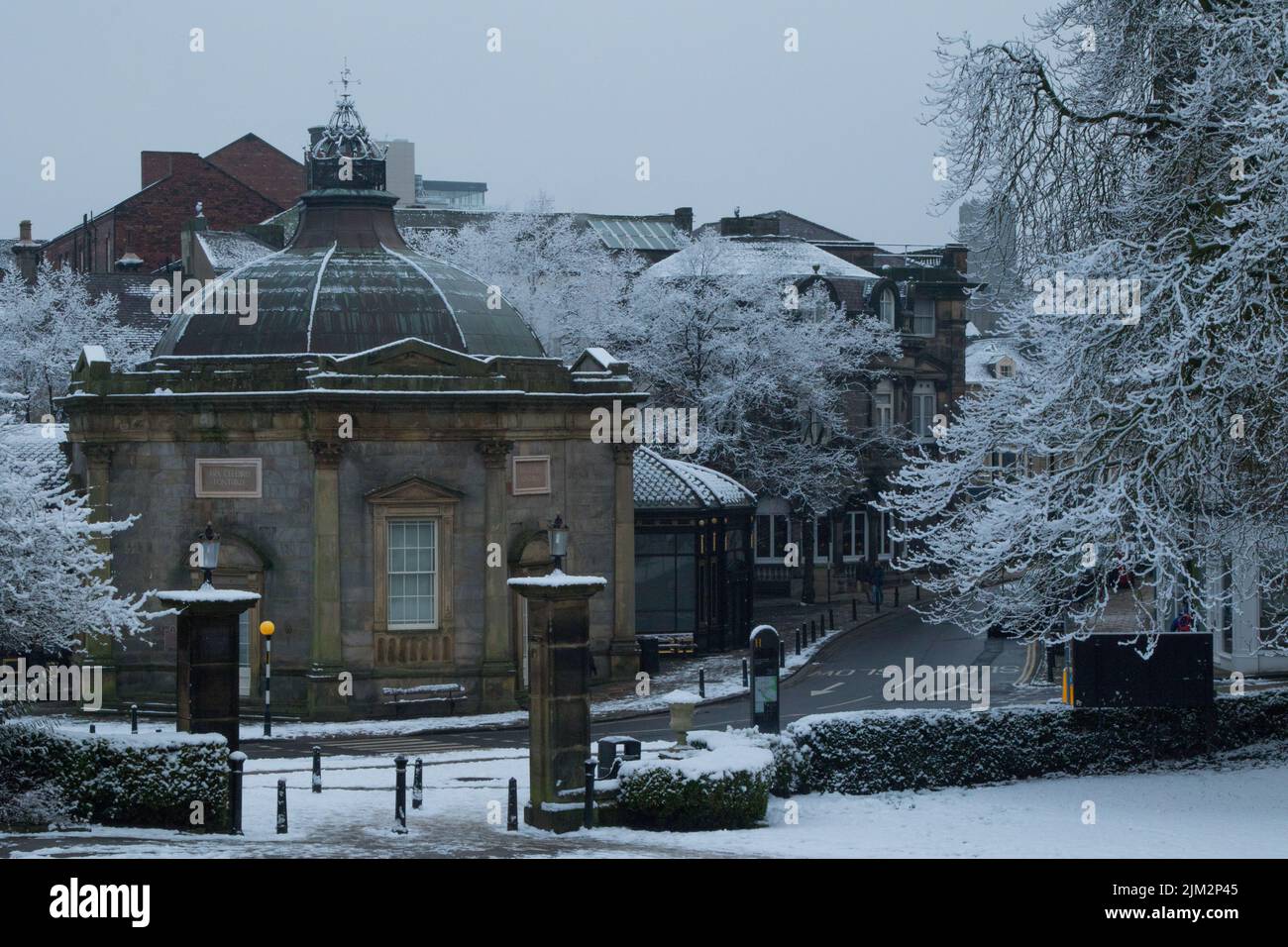 Blick auf das Royal Pump Room Museum in der Nähe des Eingangs zu den Valley Gardens an einem verschneiten Wintertag, Harrogate, North Yorkshire, England, Großbritannien. Stockfoto
