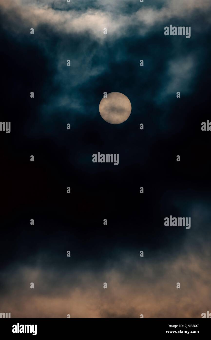 Vollmond scheint durch dunkle Wolken Stockfoto
