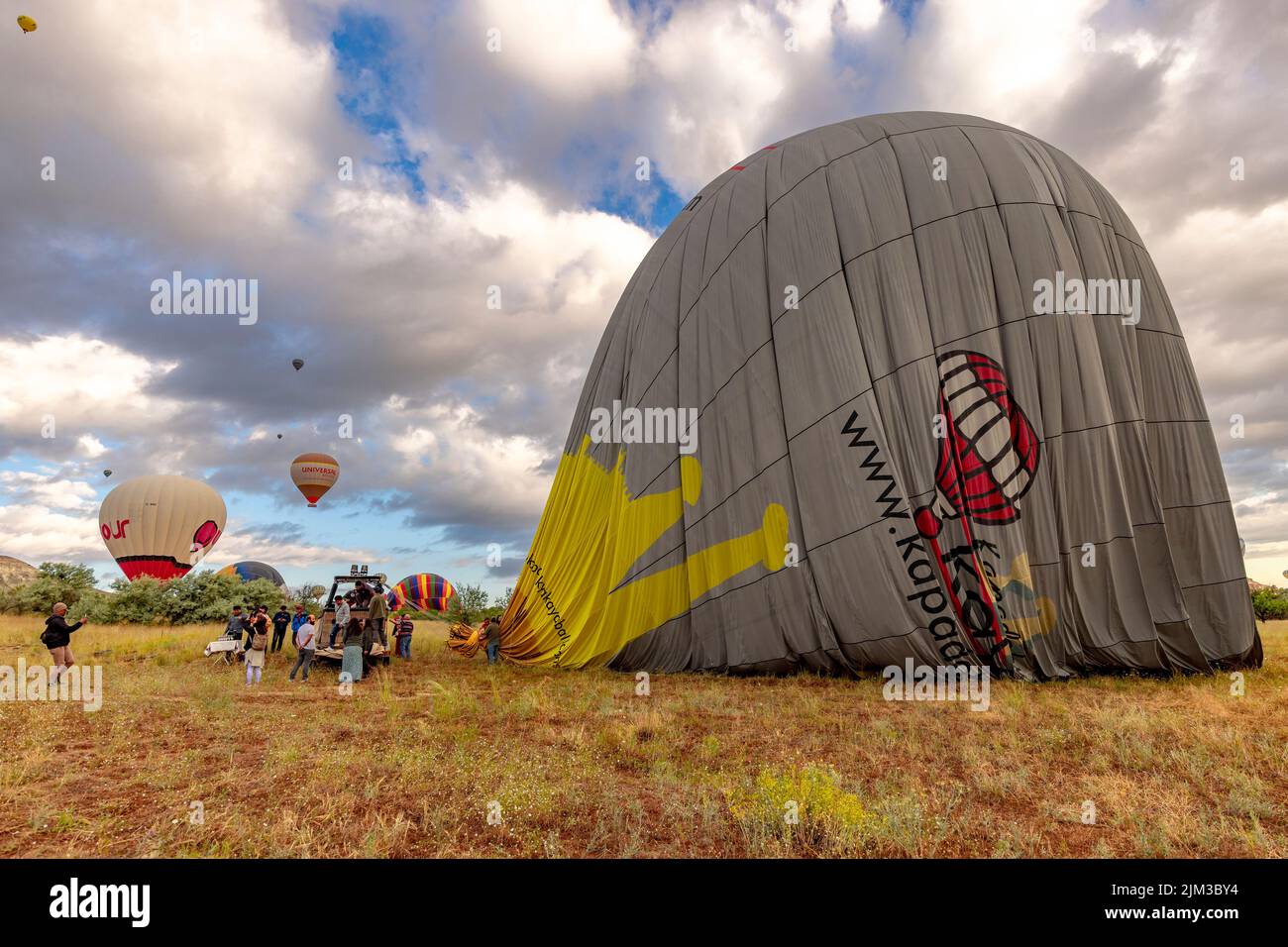GOREME/TÜRKEI - 26. Juni 2022: Gerade gelandeter Ballon wird für den Transport deflationiert. Stockfoto