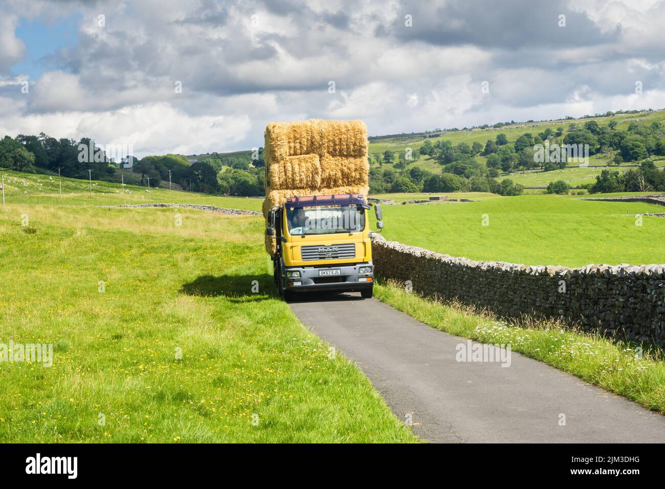 31.07.2022 Ingleton, North Yorkshire, UK Ein gelber Lastwagen mit Heubocken entlang der Oddies Lane oberhalb von Ingleton in den Yorkshire Dales Stockfoto