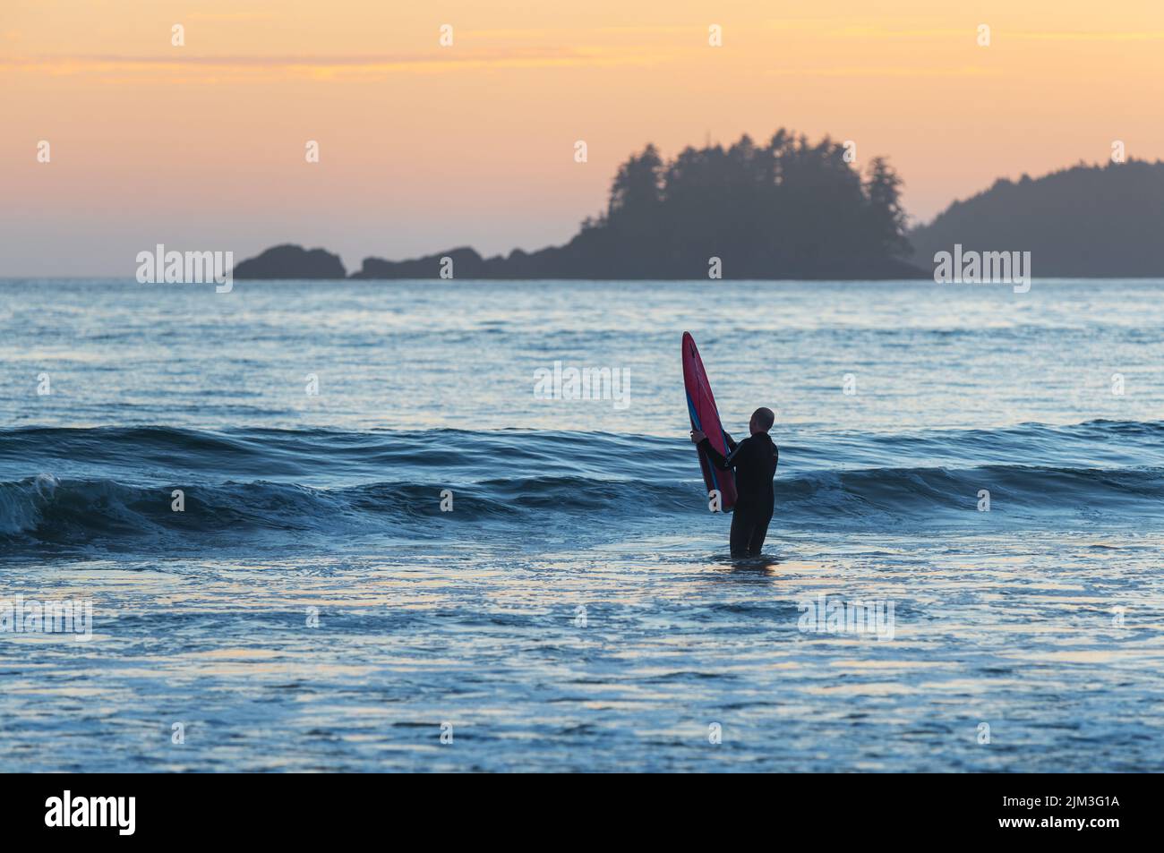 Surfer mit Surfbrett am Chesterman Beach, Tofino, Vancouver Island, Kanada. Stockfoto