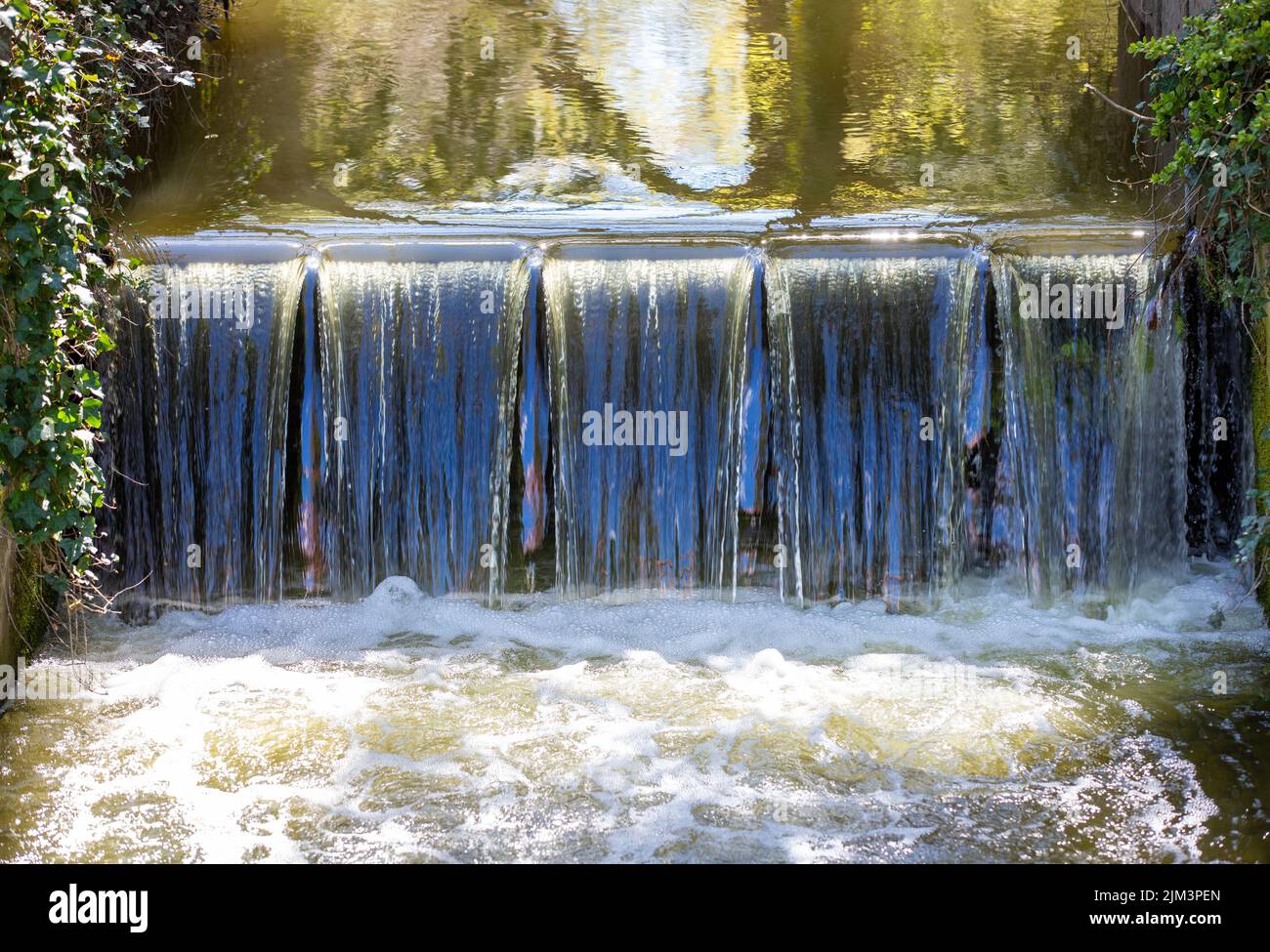 Eine malerische Aussicht auf einen künstlichen Wasserfall auf einem Bach Stockfoto