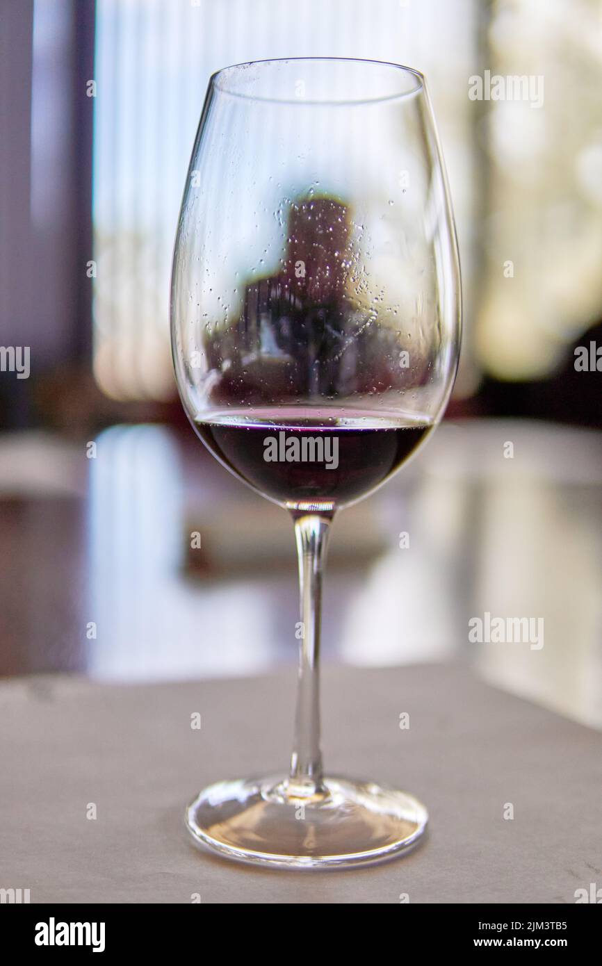 Ein Glas Rotwein im Vordergrund mit dem Hintergrund in einem Weingut in Mendoza Argentinien. Weinprobe. Selektiver Fokus Stockfoto