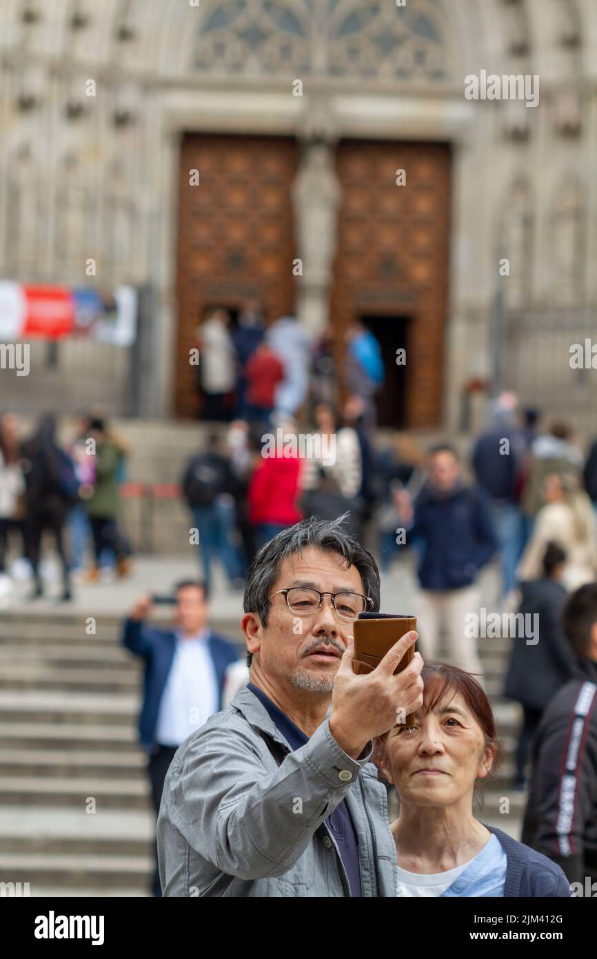 Barcelona, Spanien - 21. März 2022: Japanische Touristen machen im Urlaub ein Selfie mit ihrem Handy vor dem Caterdal in Barcelona (Spanien). Stockfoto