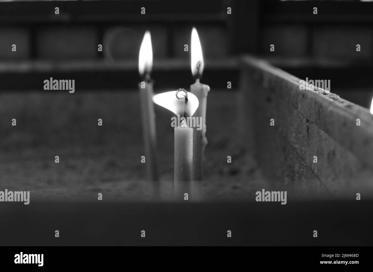 Eine Graustufenaufnahme brennender Kerzen Stockfoto