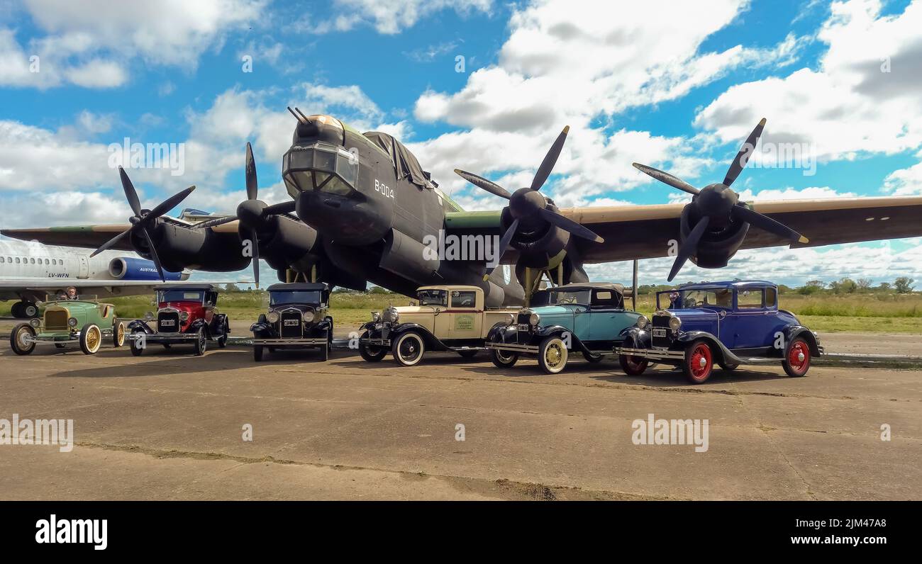 Mehrere alte Ford Model A in verschiedenen Karosserievarianten um 1930 vor einem viermotorigen Bomber Avro Lincoln MKII aus dem Zweiten Weltkrieg geparkt 1944-1967. Copyspace. Stockfoto