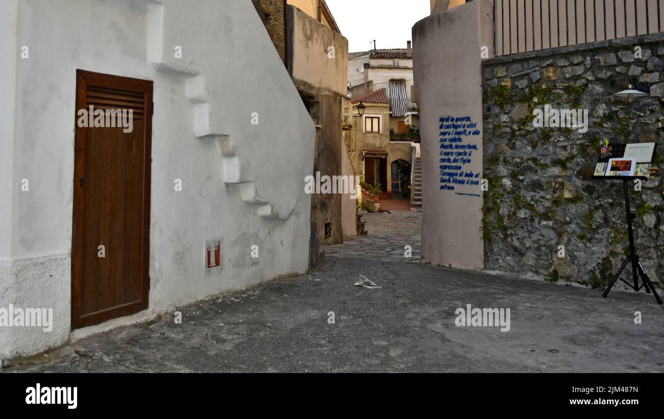 Eine schmale Straße mit gemalten Wandmalereien in einem Dorf der Region Kalabrien, Italien Stockfoto