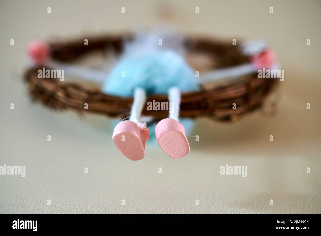 Eine Nahaufnahme der winzigen rosa Schuhe einer handgefertigten Puppe auf dem Strohzubehör Stockfoto