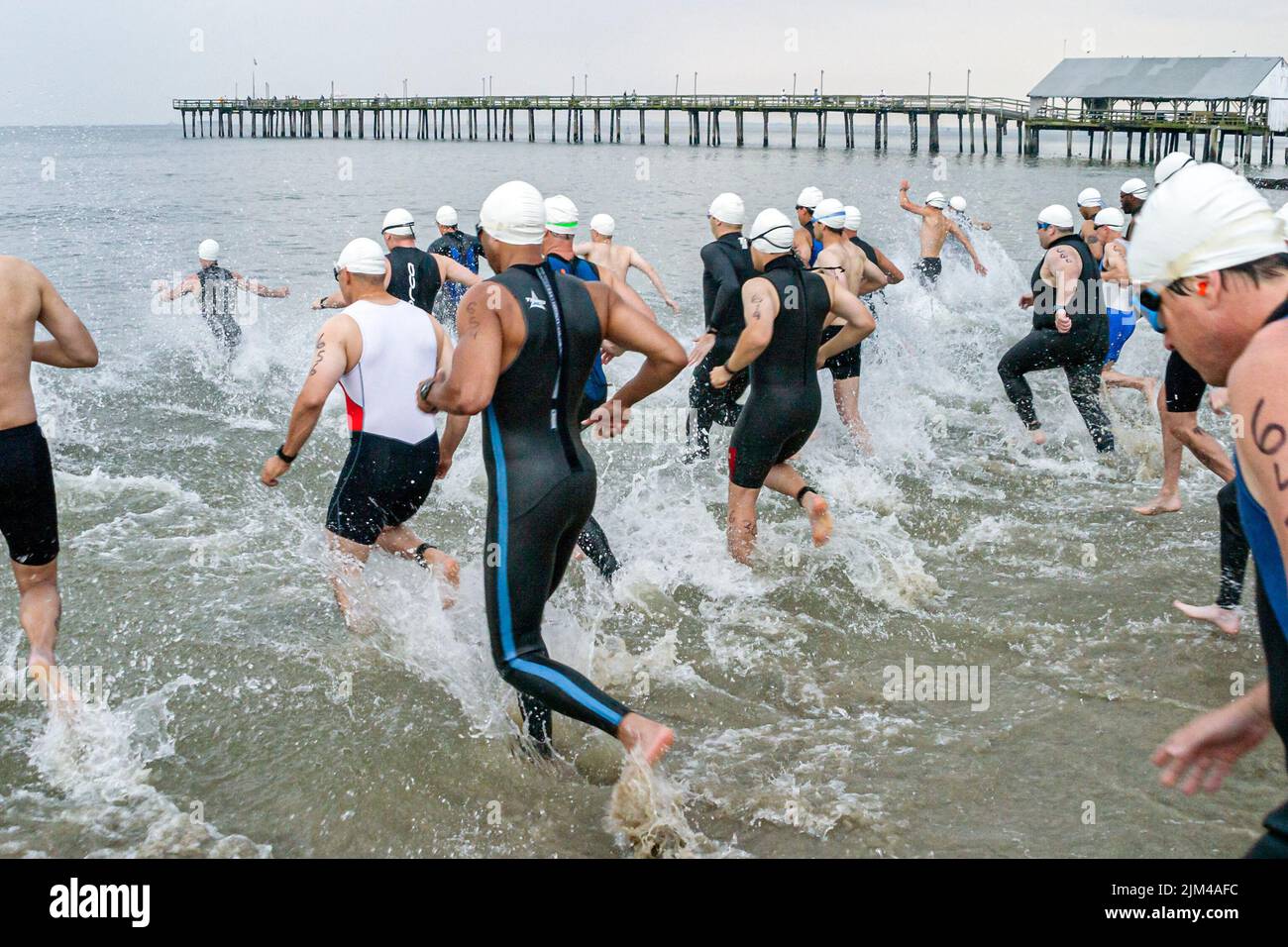 Hampton Virginia,Tidewater Area,Buckroe Beach,Tri American Triathlon jährliche Veranstaltung,Schwimmer Männer männliche Teilnehmer beginnen ein Wettlauf ins Wasser Stockfoto