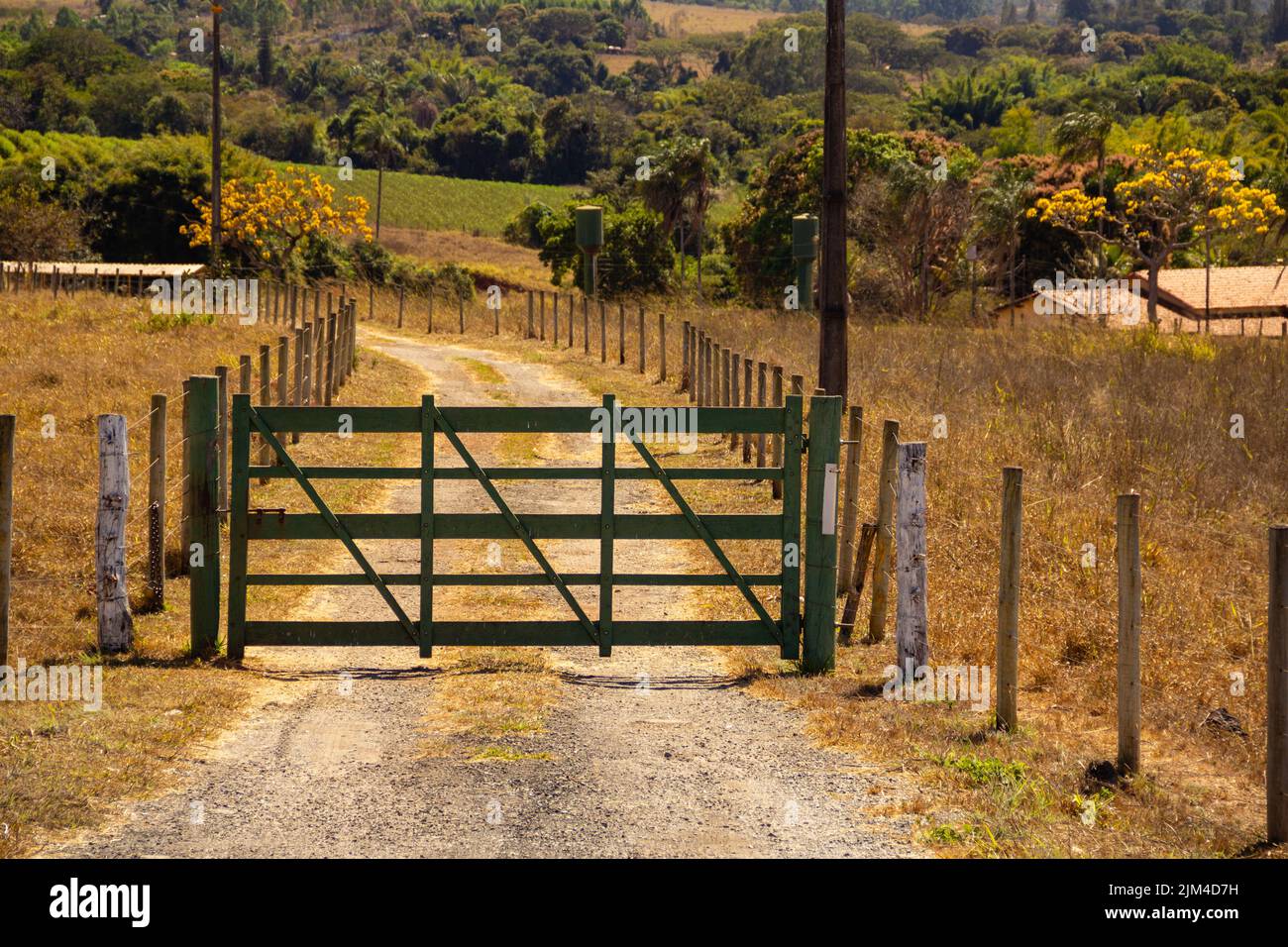 Goiania, Goiás, Brasilien – 24. Juli 2022: Ein grün bemaltes Holztor am Eingang eines Bauernhofes an der Seite einer Autobahn in Goias. Stockfoto