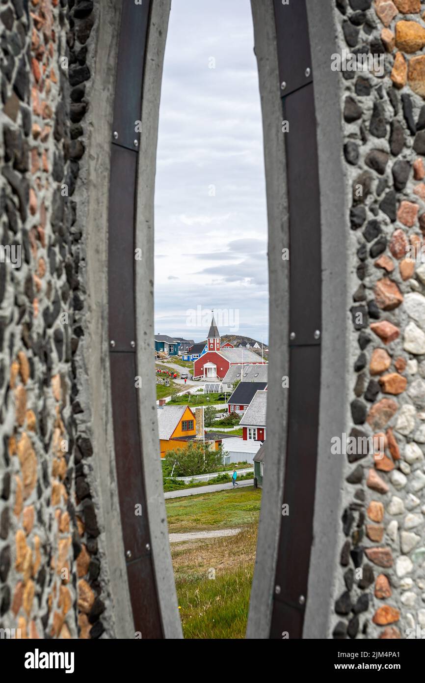 Blick auf die Kirche, die am 20. Juli 2022 durch die Säulen der Inussuk-Skulptur von Niels Molfedt über der Uferpromenade in Nuuk, Grönland, blickt Stockfoto