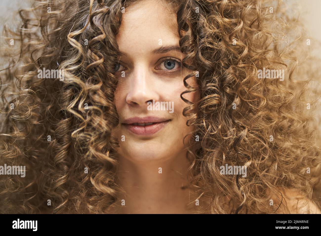 Ein schönes Porträt einer kaukasischen Frau mit sauberer, gesunder Haut und Afro-Locken. Die natürliche Schönheit der Frauen, das Konzept des Glücks. Hochwertige Fotos Stockfoto