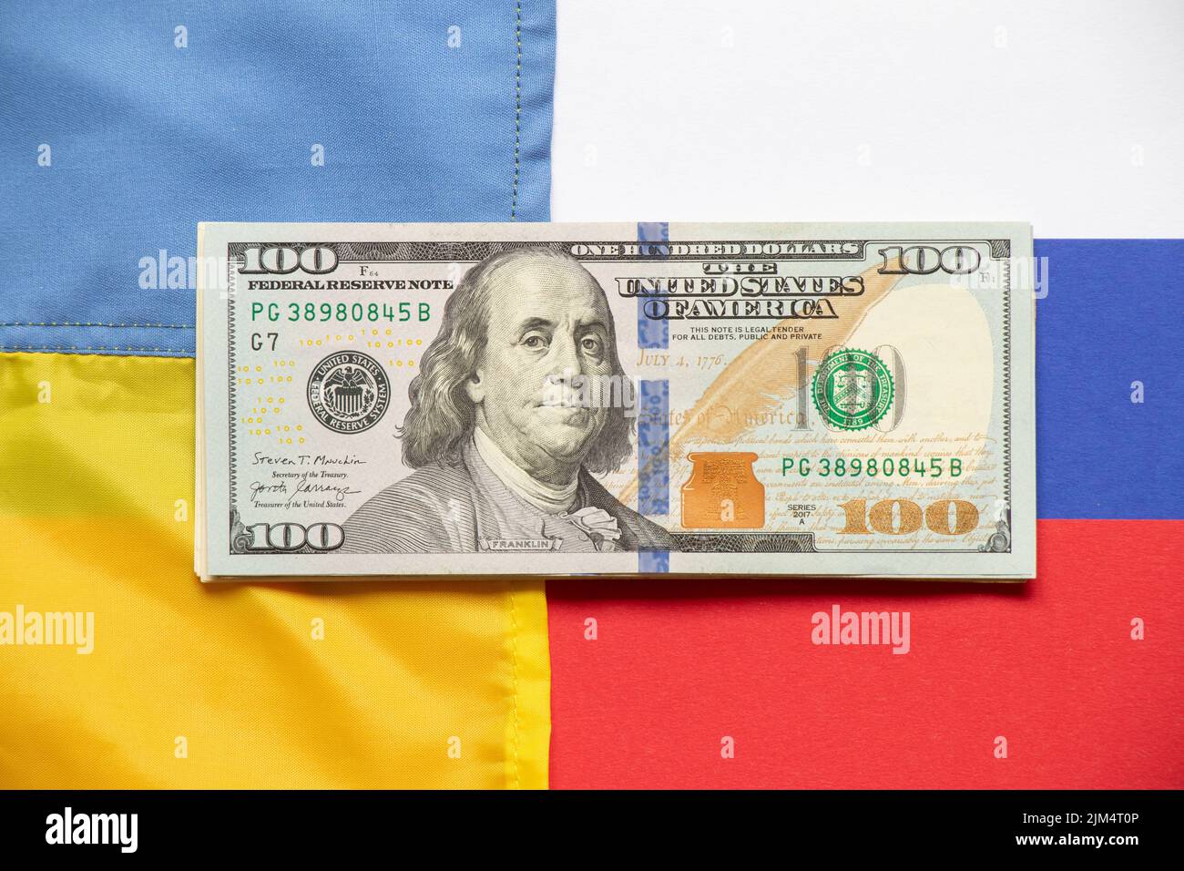 Die Flagge der Ukraine und Russlands und hundert Dollar liegen im Zentrum, der ukrainisch-russische Krieg und die Sanktionen Stockfoto