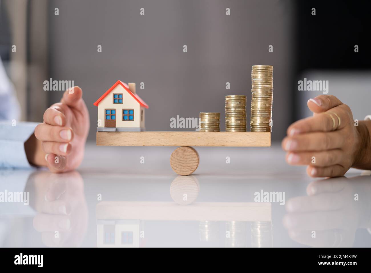 Haus Modell Balance Gleichgewicht Konzept. Immobiliengeld Stockfoto