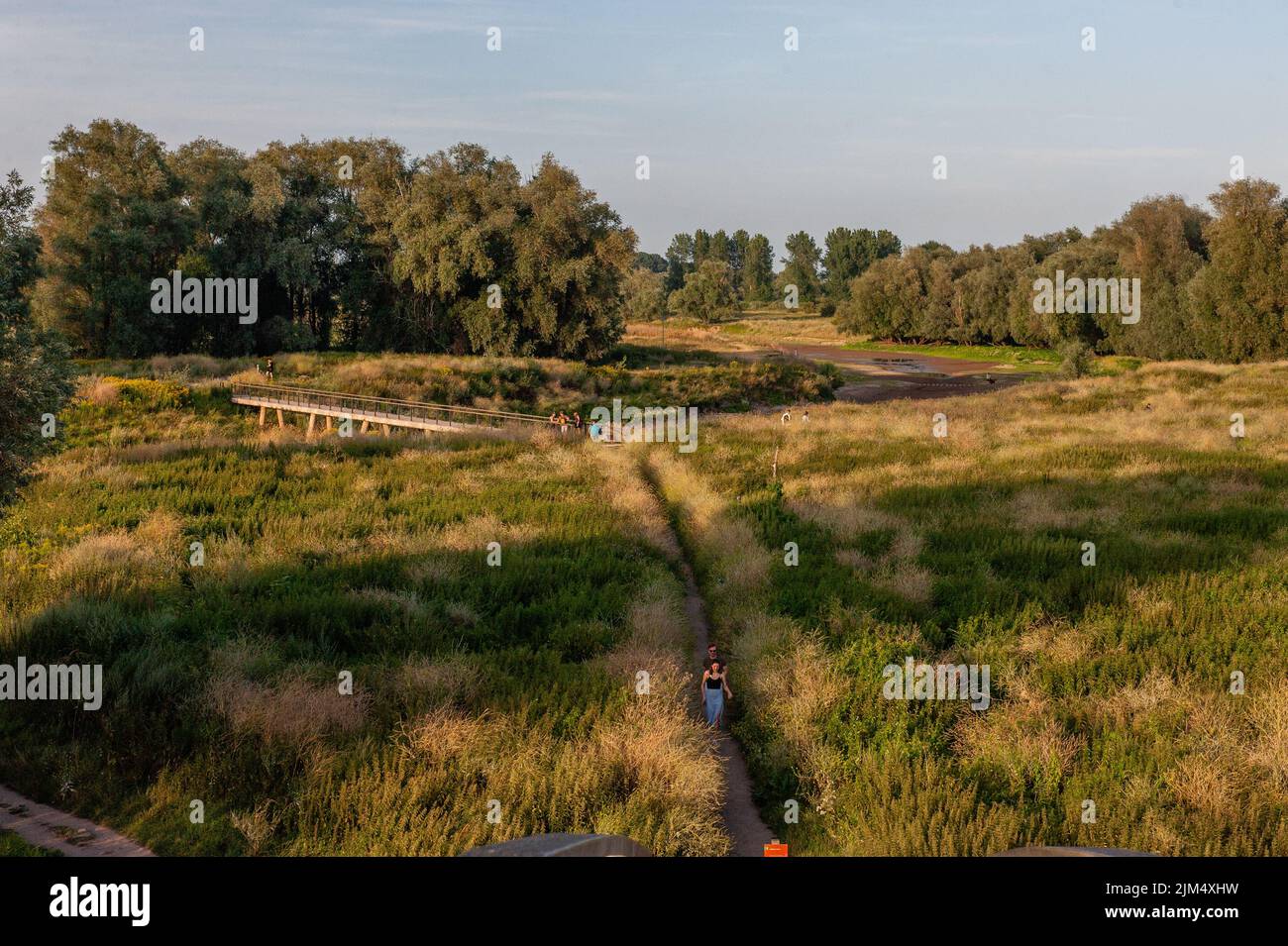 Ein Blick auf die getrocknete Landschaft rund um das Ooijpolder-Gebiet während des Sonnenuntergangs. Aufgrund der anhaltenden Dürre leiden die Niederlande offiziell an Wasserknappheit, teilte die Regierung mit. Das knappe Wasser wird gemäß den gesetzlichen Vereinbarungen verteilt, so dass Deiche, Torfböden und sehr gefährdete Naturgebiete so lange wie möglich mit Wasser versorgt werden. Weitere Maßnahmen werden in den kommenden Wochen folgen. Da zwei Drittel der niederländischen Bevölkerung unter dem Meeresspiegel leben, können Dürren in den Niederlanden schnell zu einem akuten Problem werden, was dazu führt, dass Flüsse zum Verstummen kommen und den Wasserverkehr behindern. Aufgrund der in Stockfoto