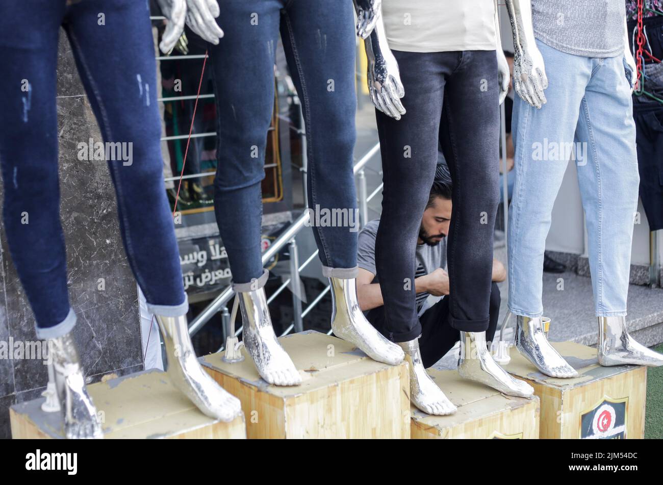 Ein Palästinenser sitzt neben Schaufensterpuppen in einem Bekleidungsgeschäft in Gaza City. Die Hamas-Führer in Gaza verhängten vor dem neuen Schuljahr eine ganze Reihe neuer Steuern auf importierte Kleidung und Büromaterialien, was begrenzte, aber seltene Proteste in der verarmten Küstenenklave auslöste. Es kommt zu einer Zeit, in der 2,3 Millionen Menschen in Gaza unter der 15 Jahre alten israelischen Blockade leiden, aber auch unter einem neuen Preisanstieg, der durch globale Lieferkettenprobleme und die russische Invasion in der Ukraine verursacht wird. Die Liste des Wirtschaftsministeriums enthält geplante Steuern auf Artikel wie verpackte Nüsse mit einem Einfuhrzoll von 2.000 Schekel Stockfoto