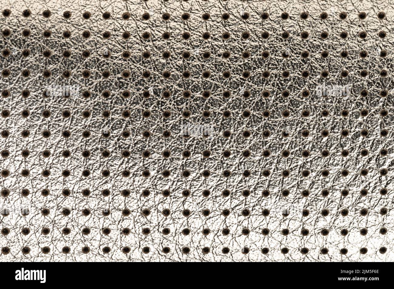 Glänzendes Silber perforiertes Leder Hintergrund Makro Nahaufnahme Stockfoto