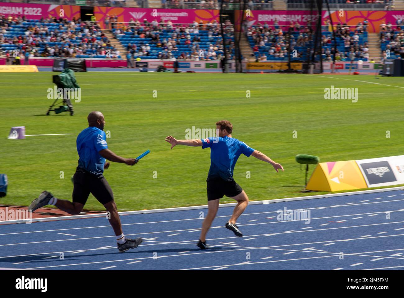 Birmingham, Großbritannien, 4.. August 2022. Mark Rhodes (TV-Moderator für Kinder) empfängt den Staffelstab von Darren Harriott (Komiker) während der 4 x 100m-Staffel im Teil Sport Relief All-Stars der Veranstaltung bei den Commonwealth Games 2022. Das Team gewann das Rennen. Die Veranstaltung Sport Relief All-Stars wird von der BBC im Rahmen der Commonwealth Games und Sport Relief gezeigt. Quelle: Martin Anderson/Alamy Live News Stockfoto