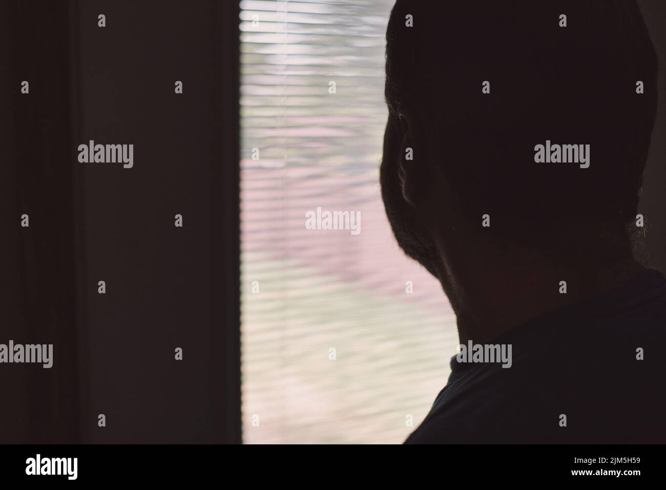 Saisonale affektive Störung - TRAURIG - depressiver Mann, der ziellos aus dem Fenster schaut - psychische Gesundheit Stockfoto