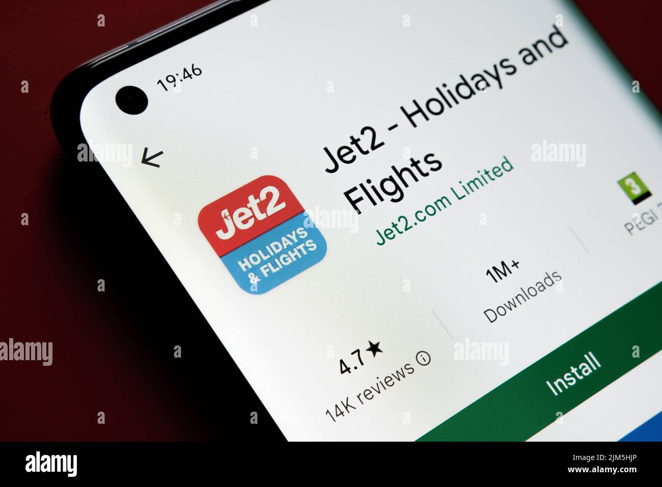 Jet2 App im Google Play Store auf dem Smartphone-Bildschirm auf rotem Hintergrund gesehen. Nahaufnahme mit selektivem Fokus. Stafford, Großbritannien, A Stockfoto