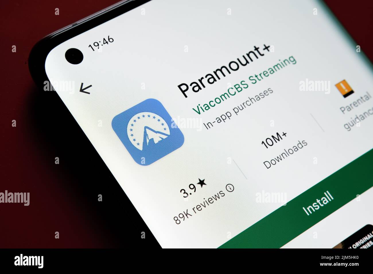 Paramount Plus App im Google Play Store auf dem Smartphone-Bildschirm auf rotem Hintergrund zu sehen. Nahaufnahme mit selektivem Fokus. Stafford, United Stockfoto