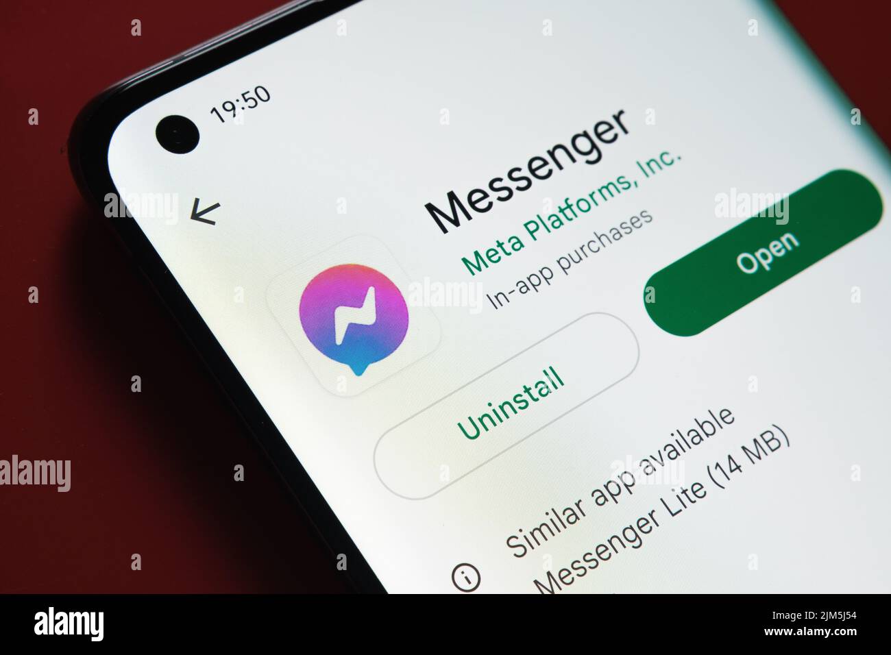 Facebook Messenger-App im Google Play Store auf dem Smartphone-Bildschirm auf rotem Hintergrund angezeigt. Nahaufnahme mit selektivem Fokus. Stafford, Uni Stockfoto