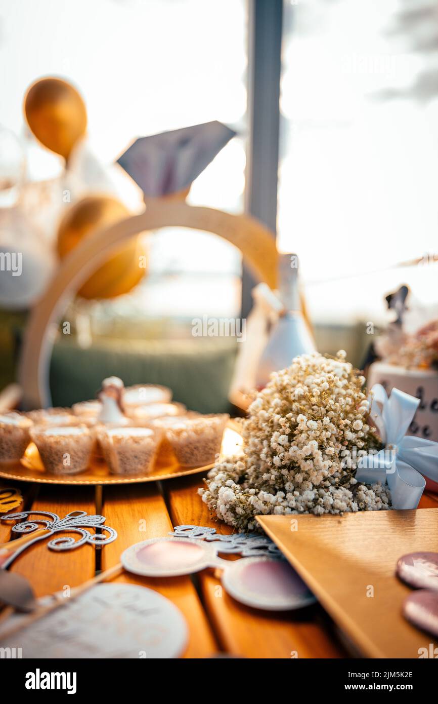 Eine Nahaufnahme eines Straußes auf einem Tisch mit ein paar Keksen und Dekorationen für eine Verlobung Stockfoto