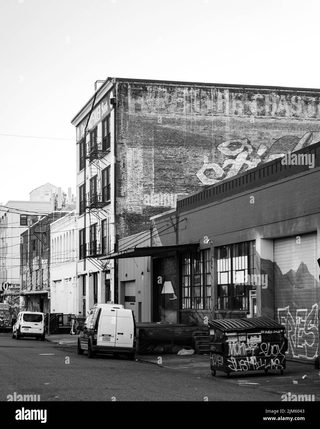 Eine Graustufenaufnahme eines Autobahnschildes, eingerahmt von einer Autobahnrampe und einem Backsteingebäude in Portland Stockfoto