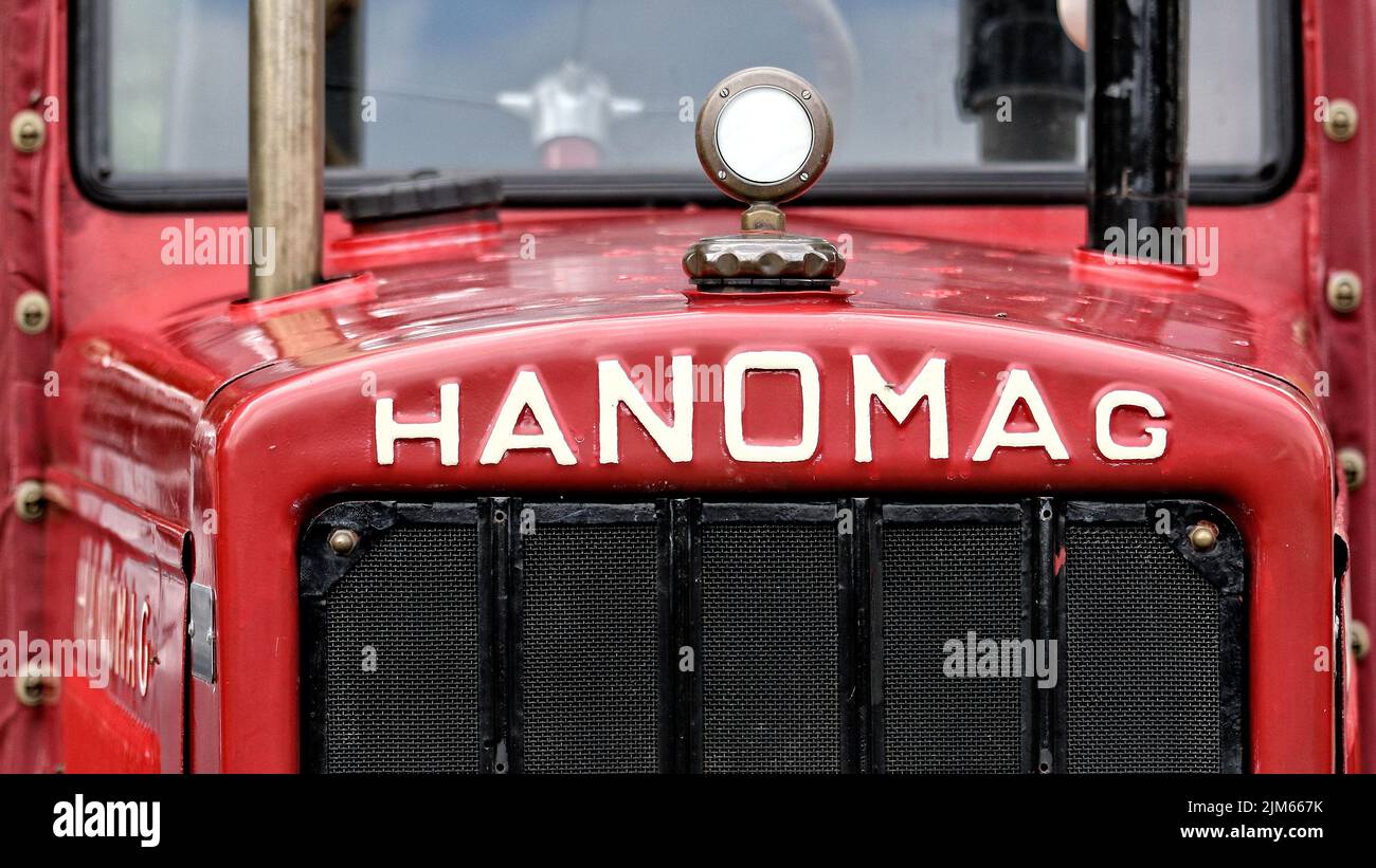 Hier ist eine Detailaufnahme eines roten Traktors und eines weißen Schreibhanomags, der in hannover produziert wurde Stockfoto