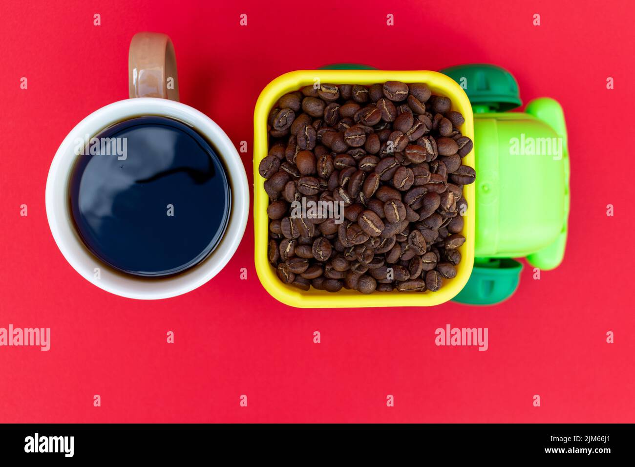 LKW, der Kaffeebohnen und eine Tasse Kaffee transportiert. Kaffeekonzept Stockfoto